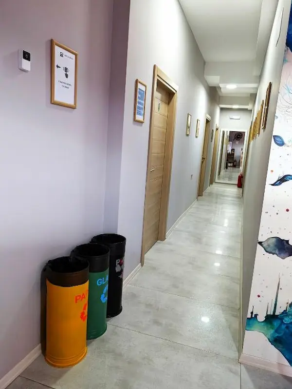 Clean and bright hallway inside Easy Apartments in Kumanovo with framed artwork and recycling bins